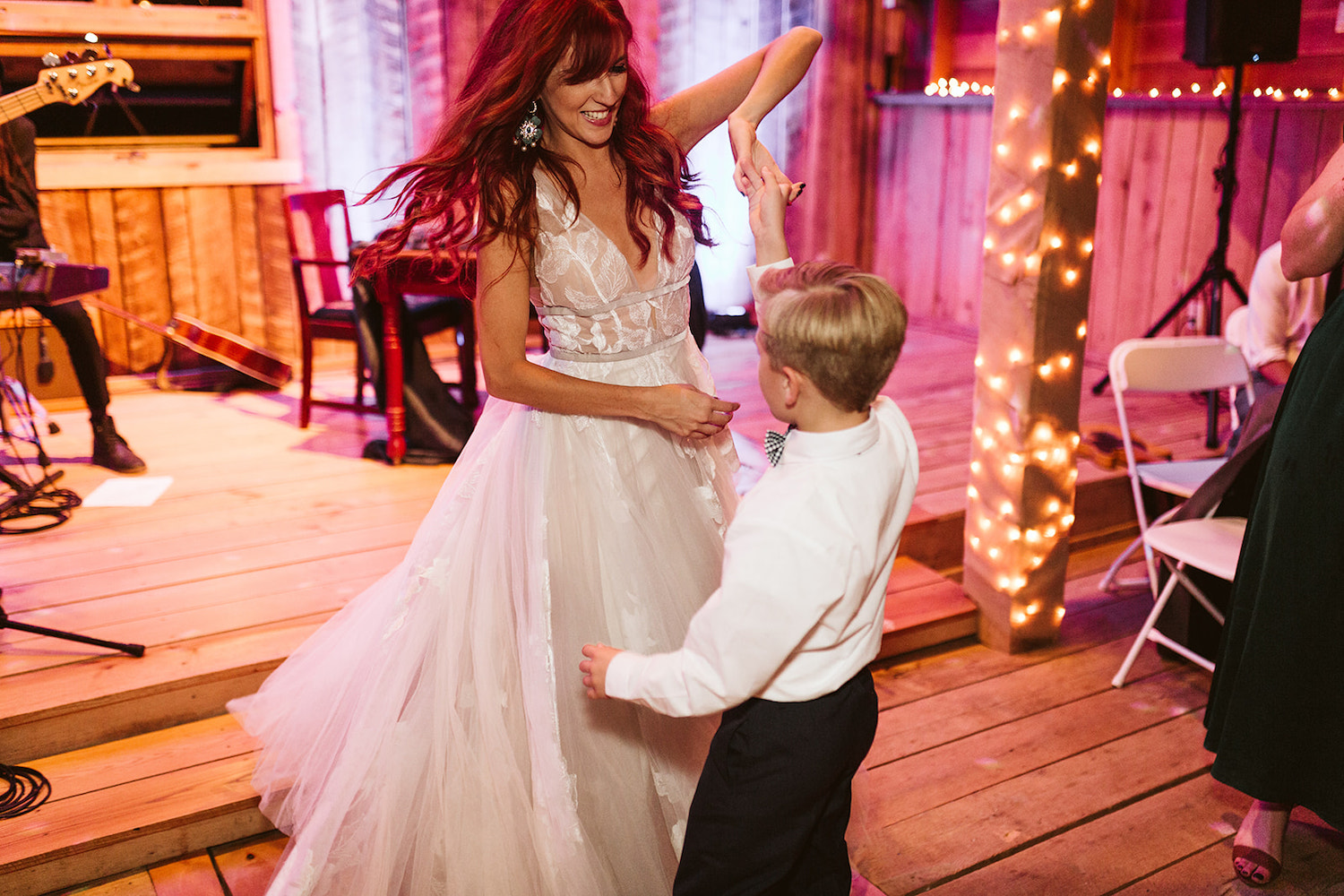 bride dances with young boy near band stage