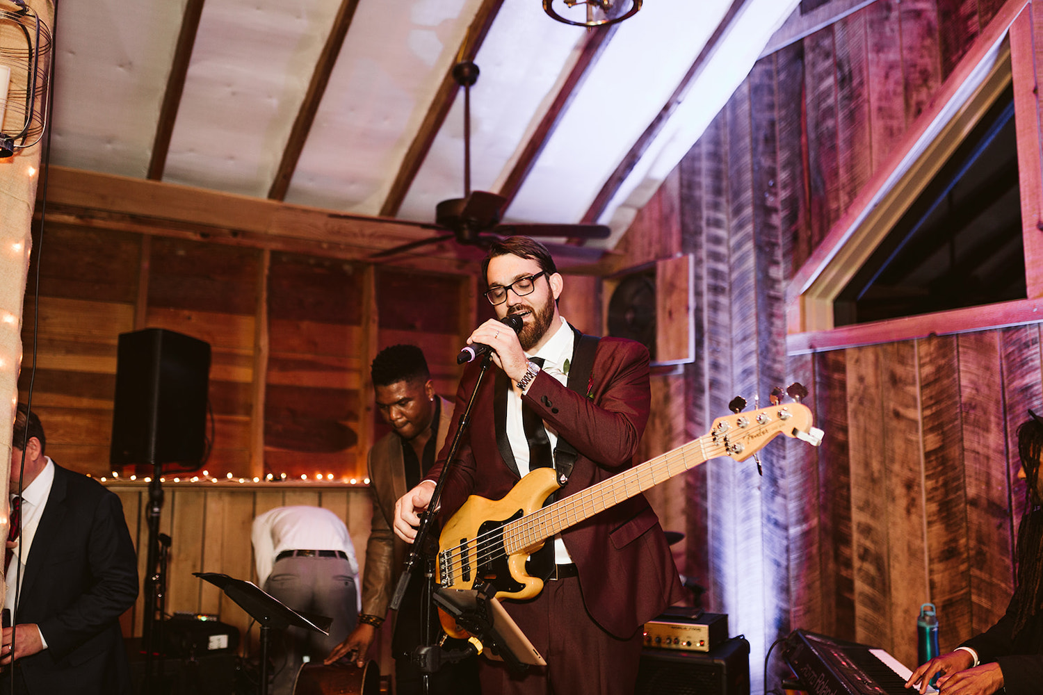 groom sings into microphone as his band plays