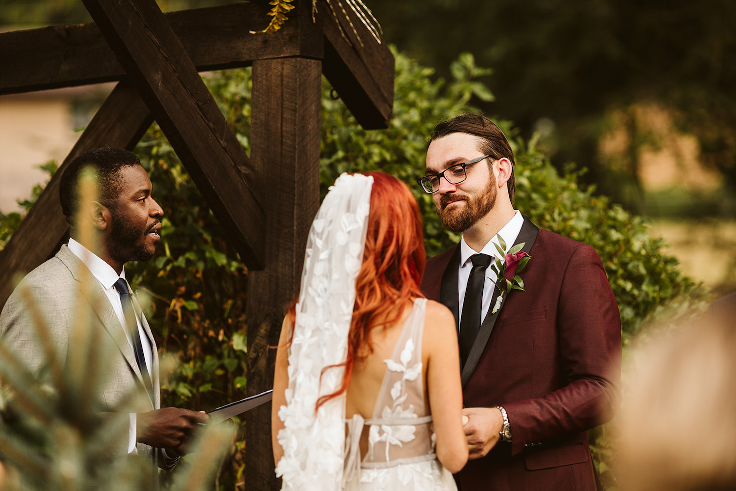 groom looks at bride while officiant reads to them