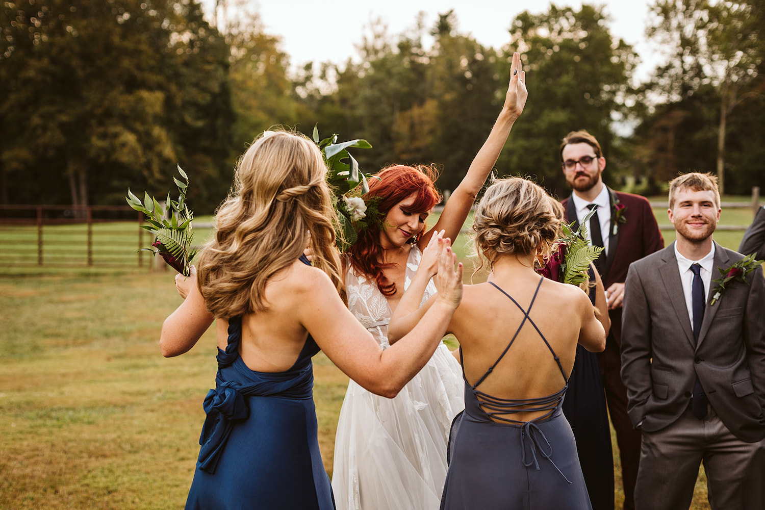 bride and bridesmaids raise their hands in celebration