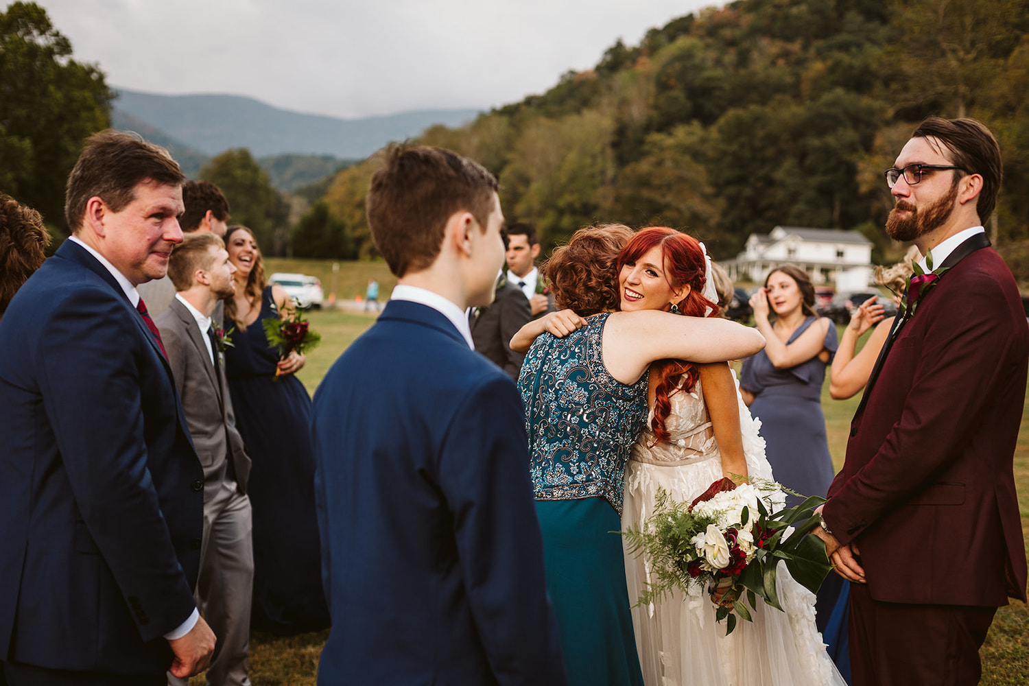 bride hugs her mother while others look on