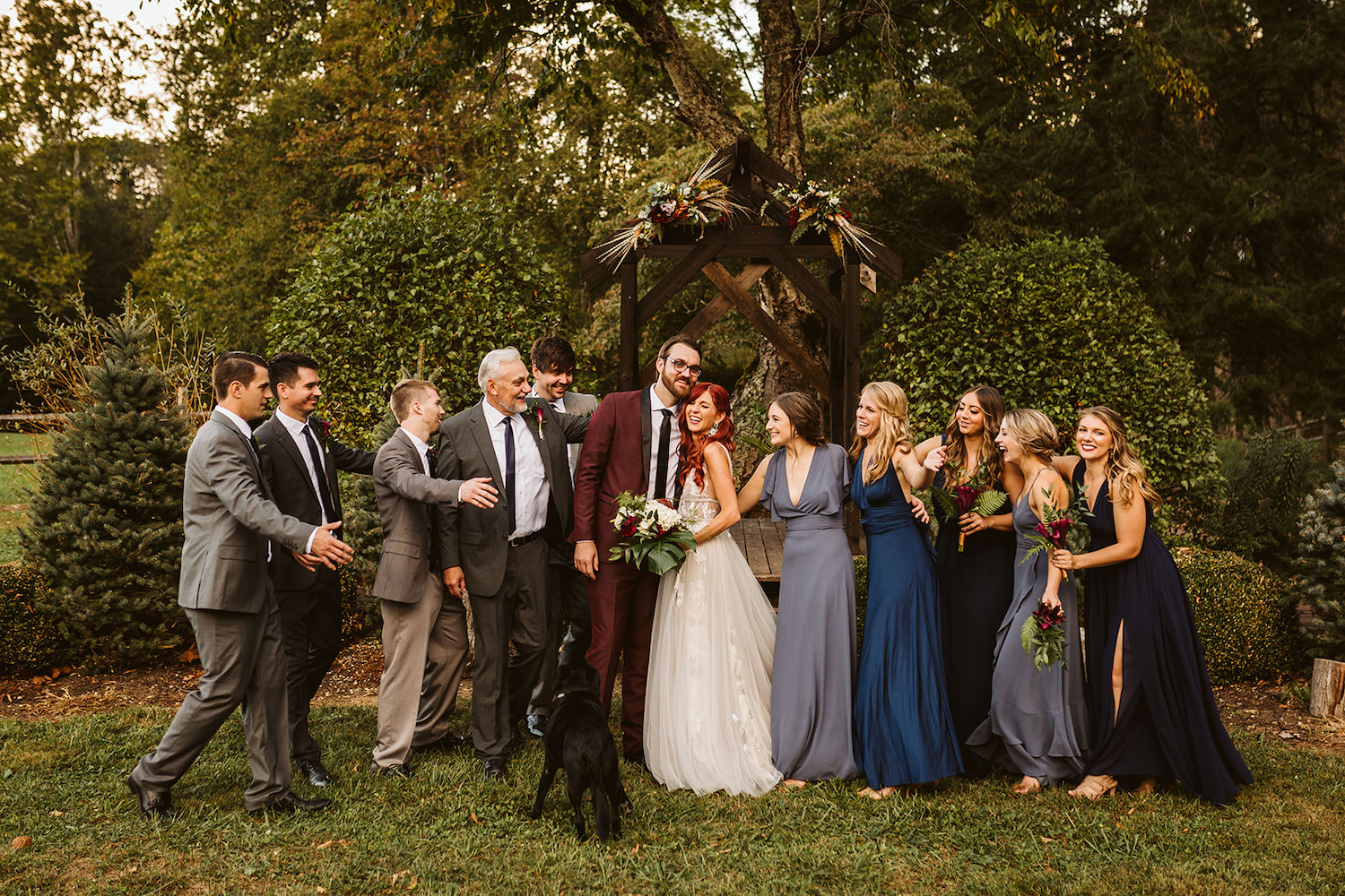 bride and groom hug as bridal party comes together for a group hug