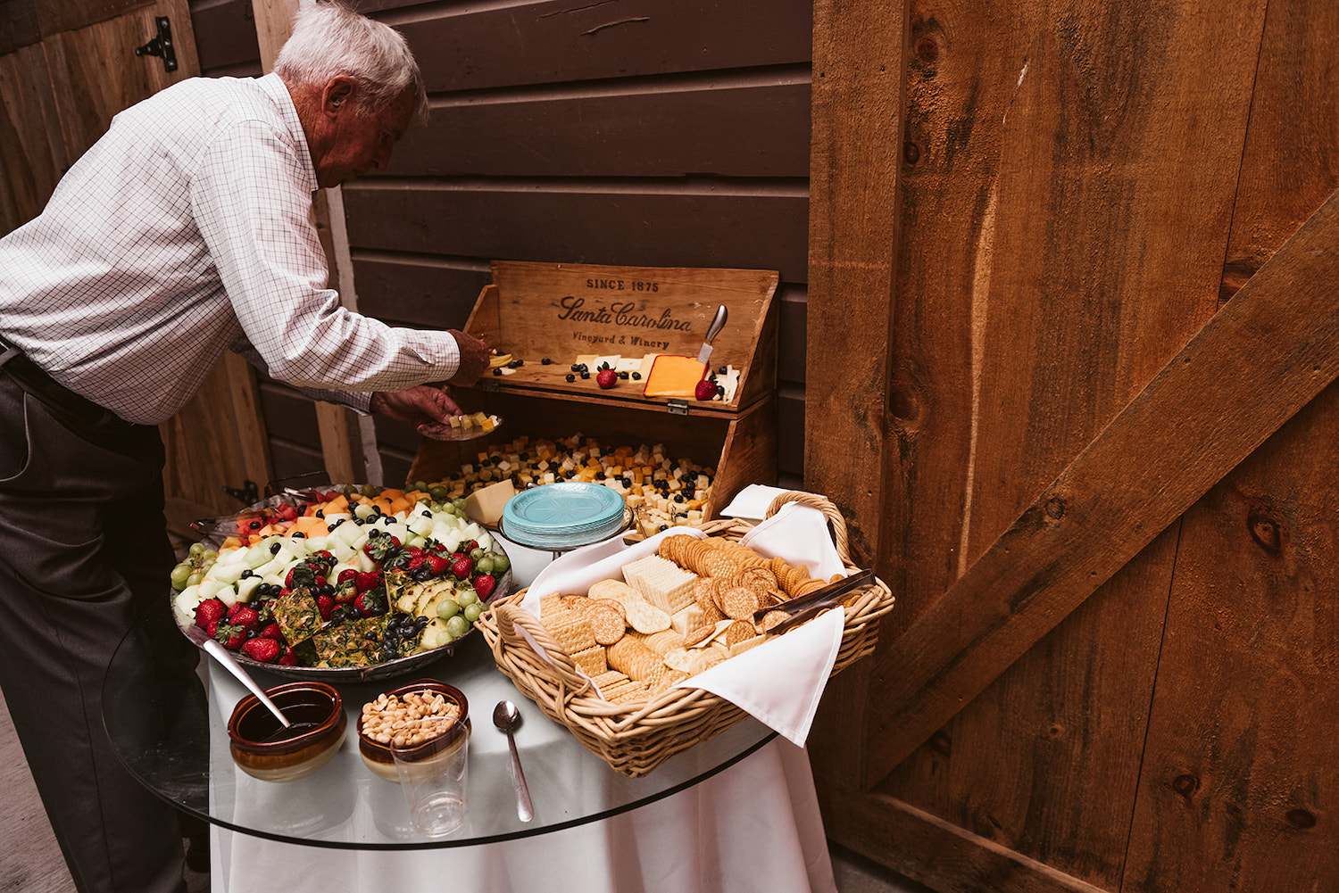 man chooses cheese and fruit from a snack table