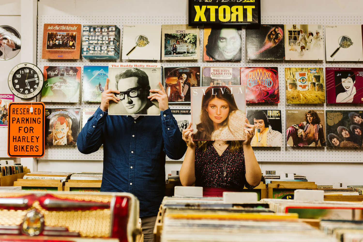 man and woman hold record folders in front of their faces at record shop in Chattanooga, Tennessee