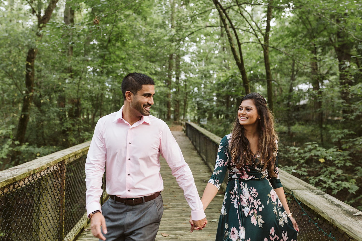 man in light pink shirt holds hands with woman in green dress at Chattanooga's Reflection Riding Arboretum and Nature Center