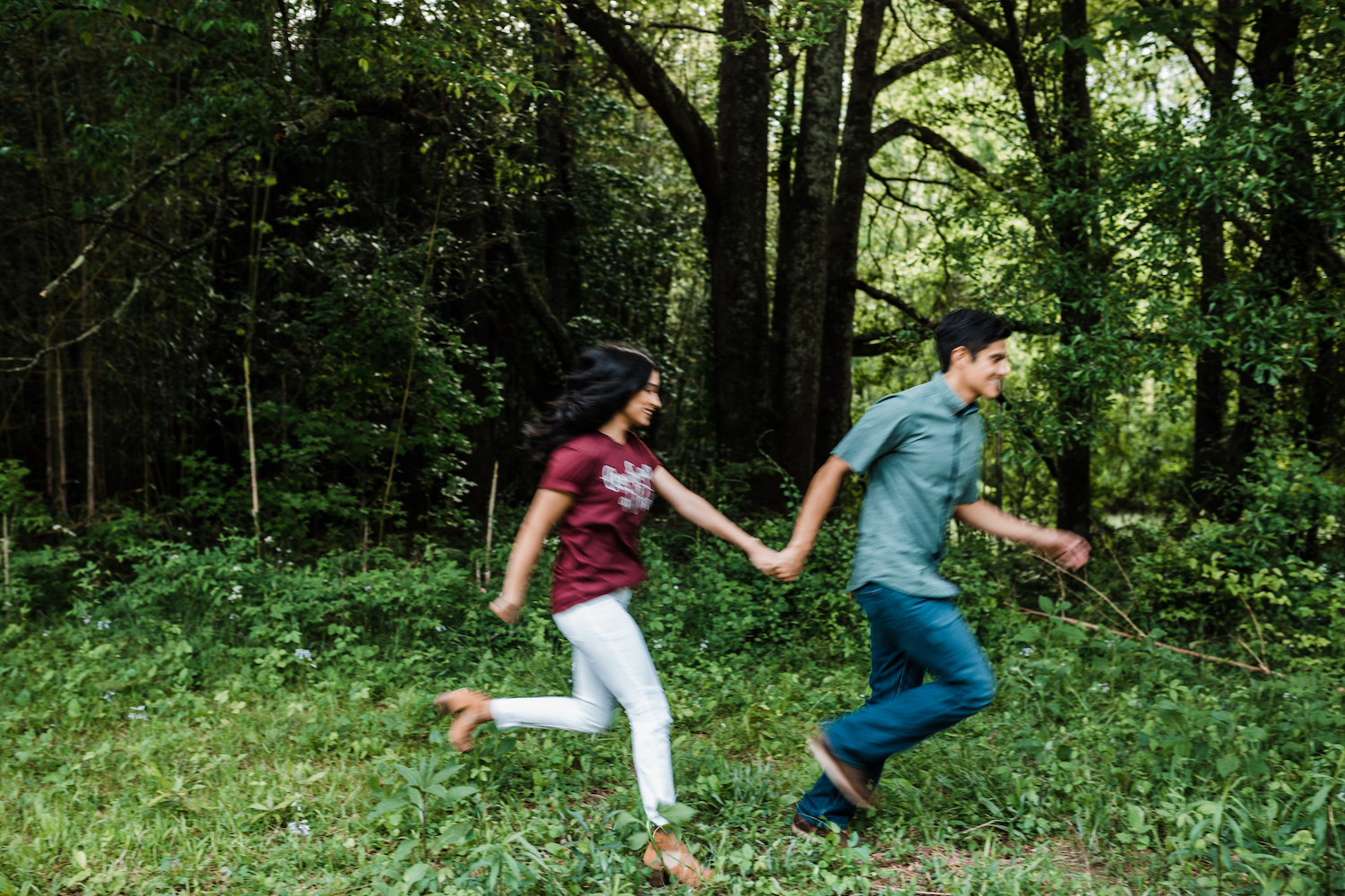 man and woman hold hands and run through grass at Chattanooga's Reflection Riding Arboretum and Nature Center