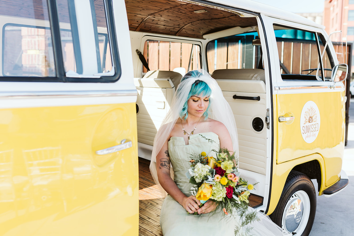 blue hair bride in strapless gown holding bright bouquet sits on floor of yellow vintage VW bus in Chattanooga Tennessee