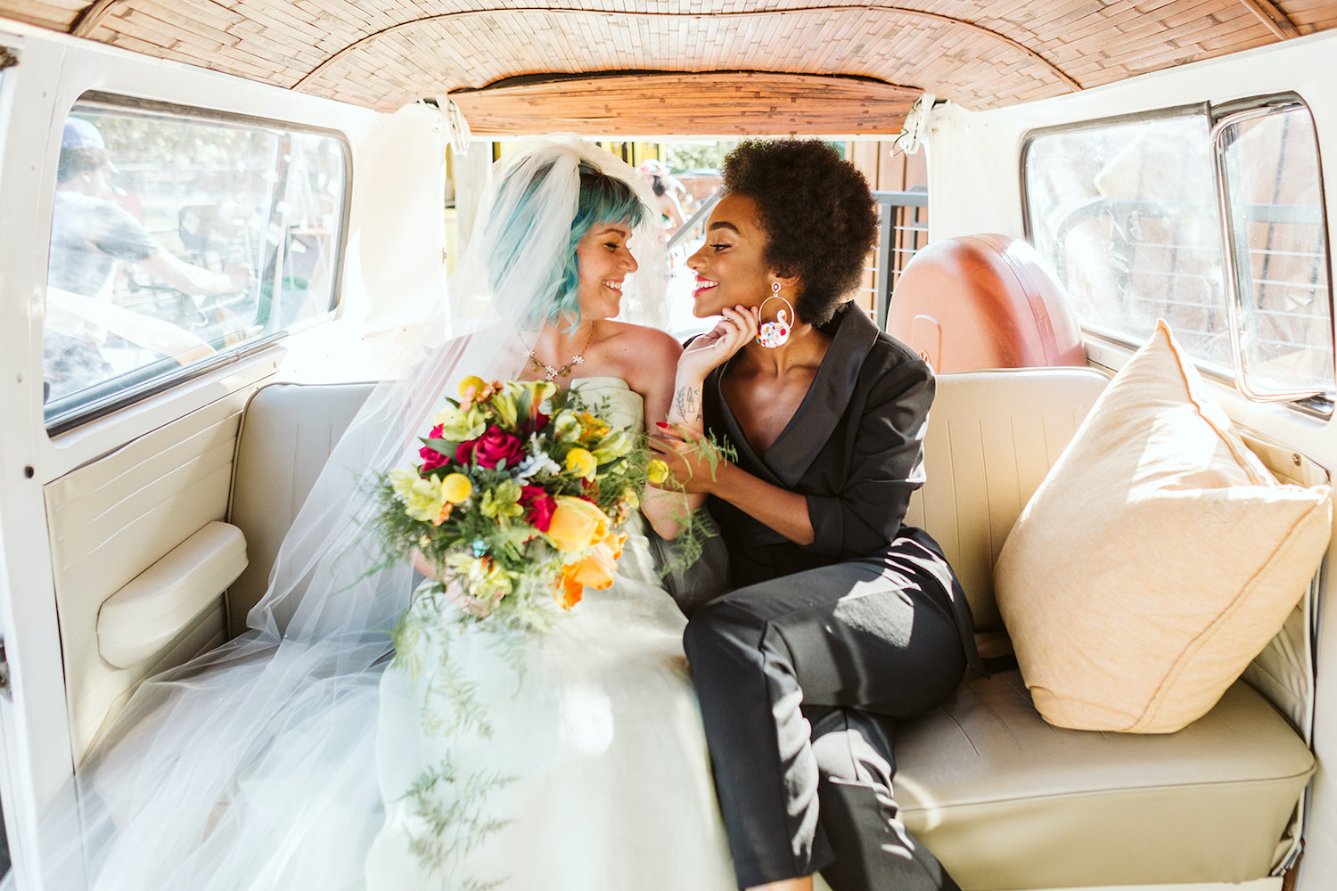 bride with blue hair caresses her partner's chin in backseat of vintage VW bus at LGBTQ wedding in Chattanooga styled shoot