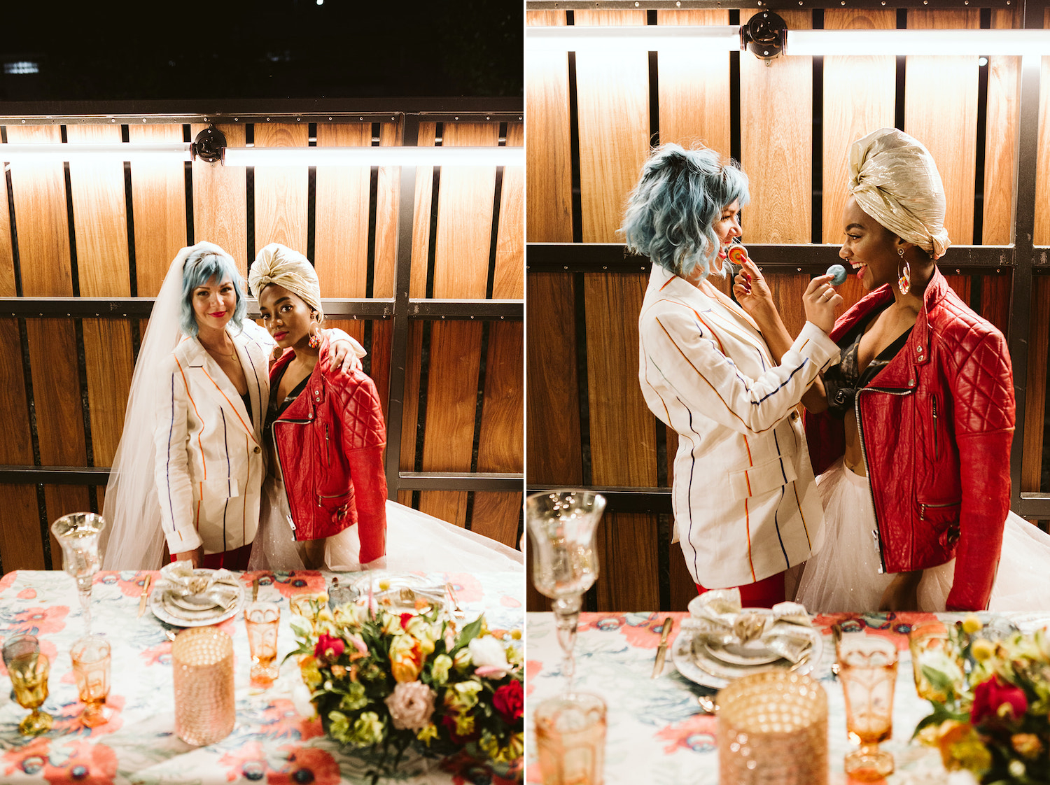 two brides stand at colorfully decorated table, feeding each other macaroons