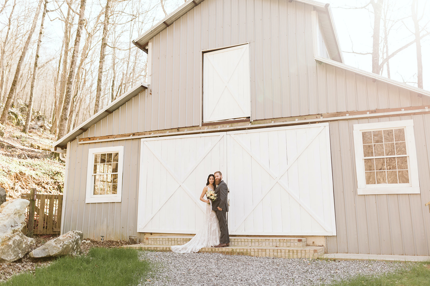 bride and groom stand together on steps in front of Oakleaf Cottage wedding