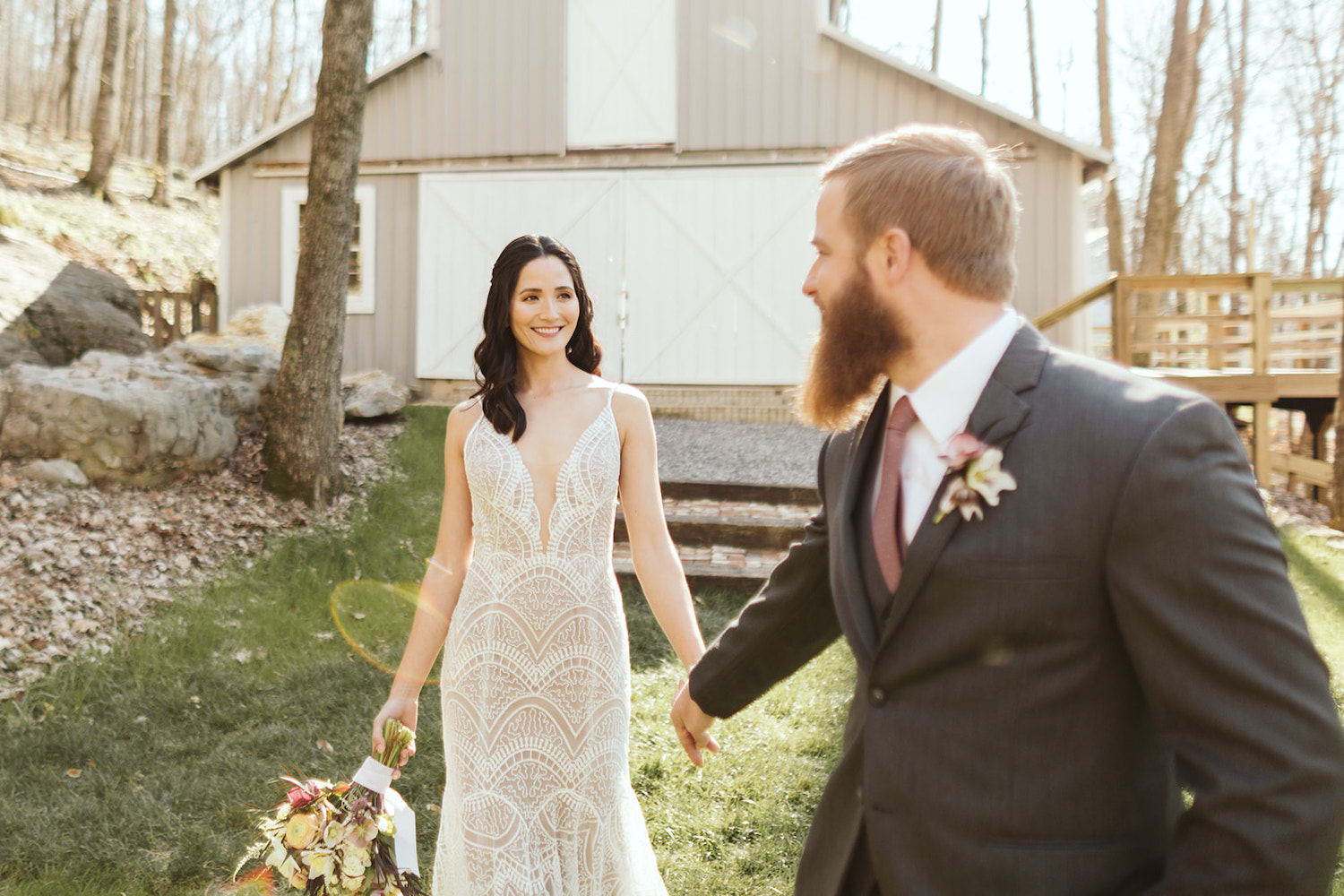 bride and groom hold hands and walk in the lawn in front of Oakleaf Cottage wedding