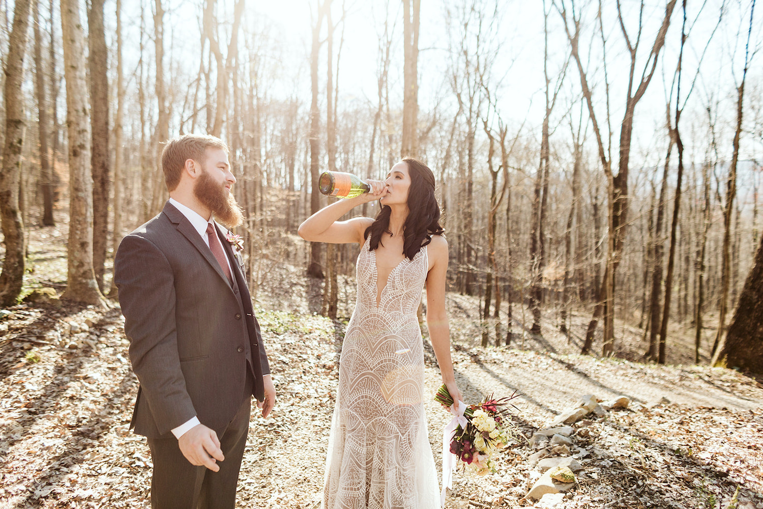 bride drinks champagne from the bottle in the woods near Oakleaf Cottage on Lookout Mountain