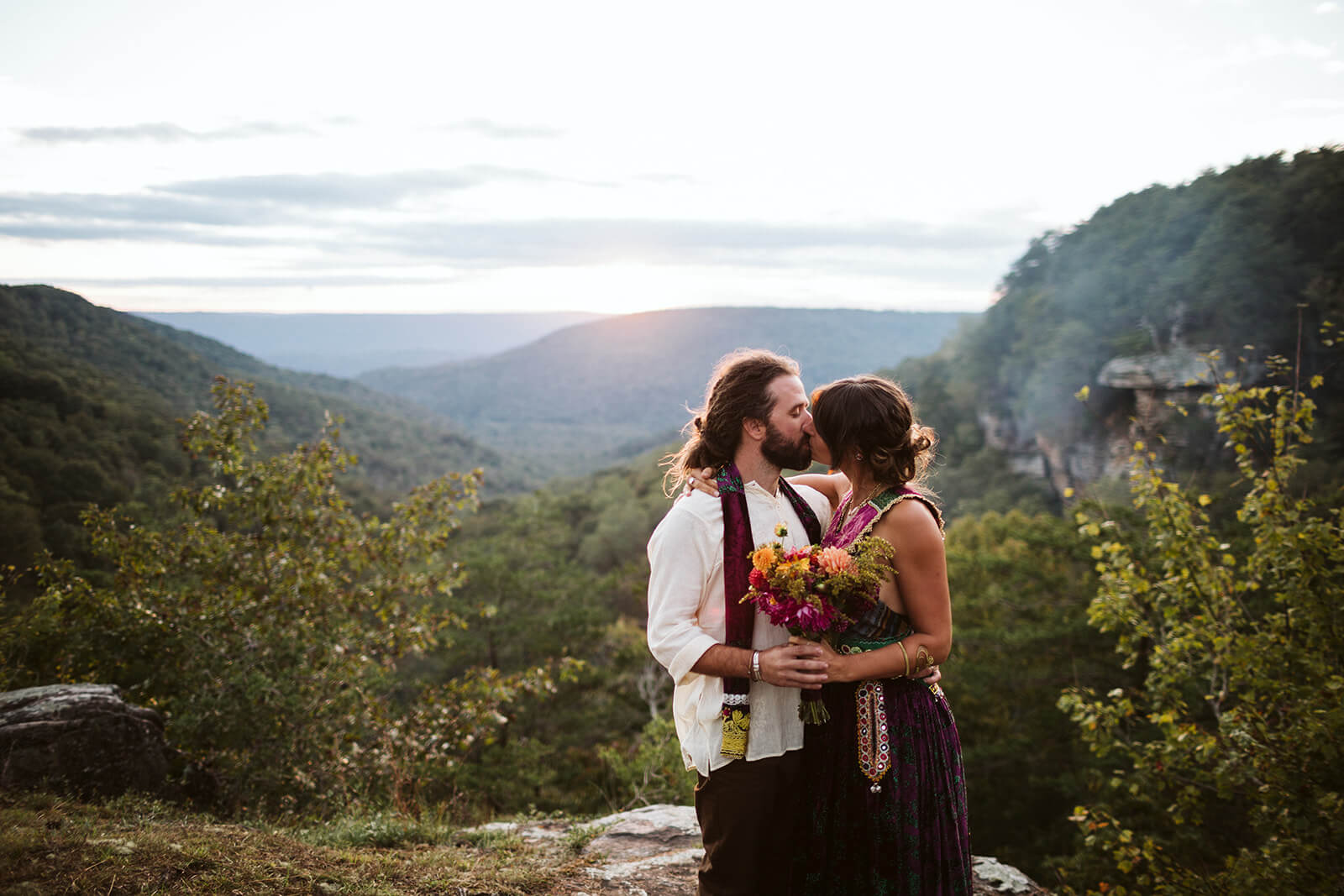 A bride and groom kiss on a ridge at their mountain wedding venue in Chattanooga, TN.