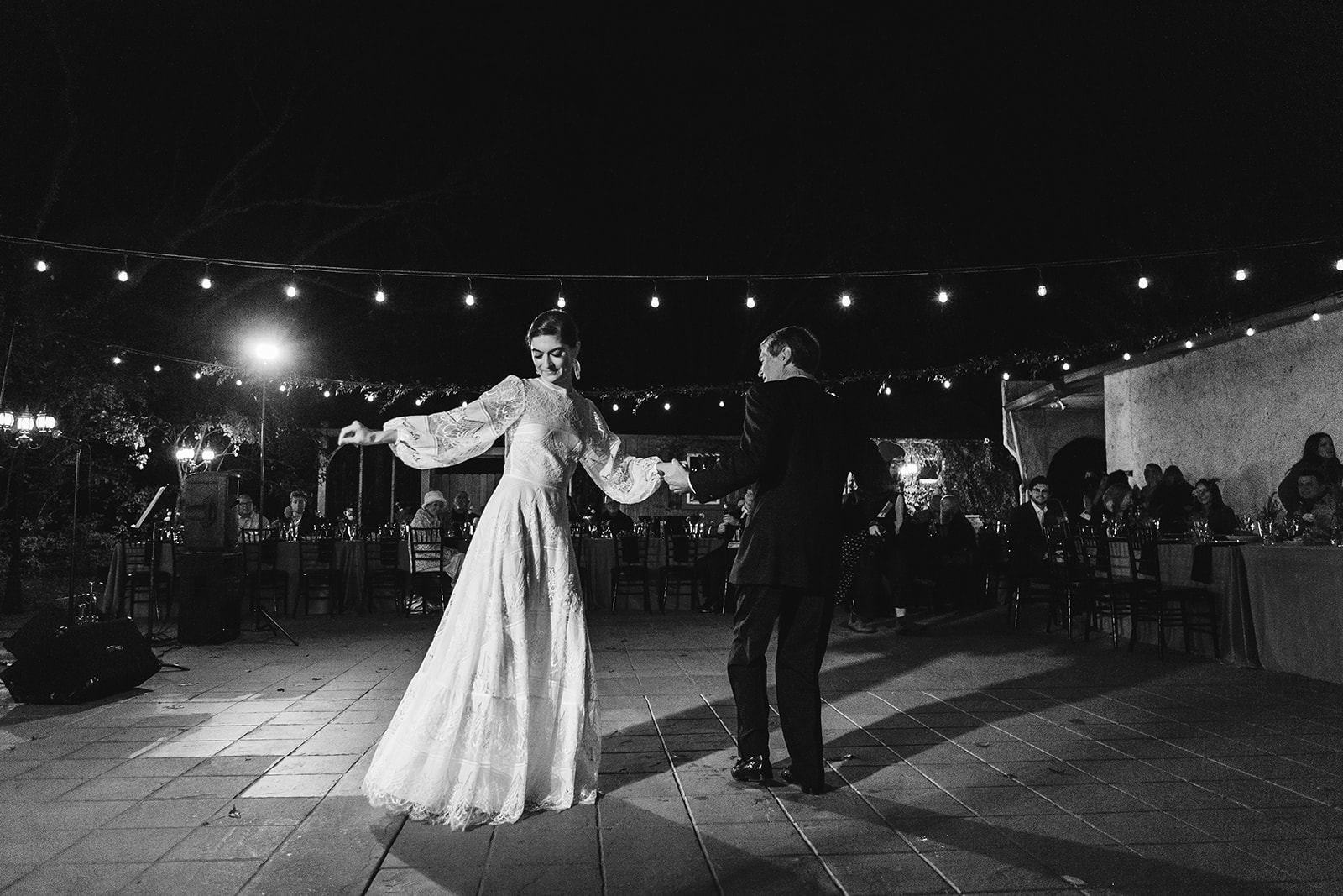 A black and white photo of a bride and groom sharing their first dance.