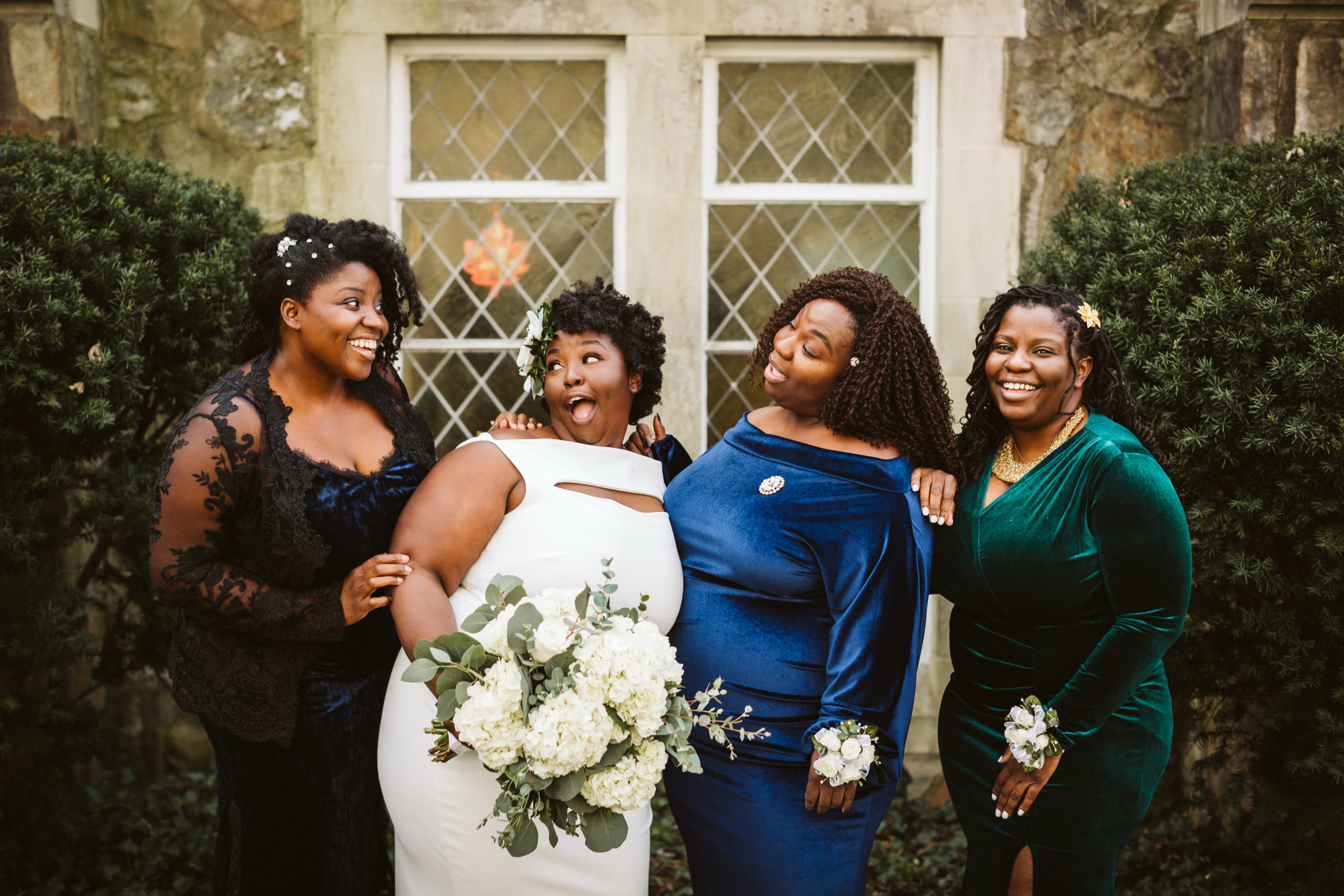 A bride and her family laugh together while posing for photos.