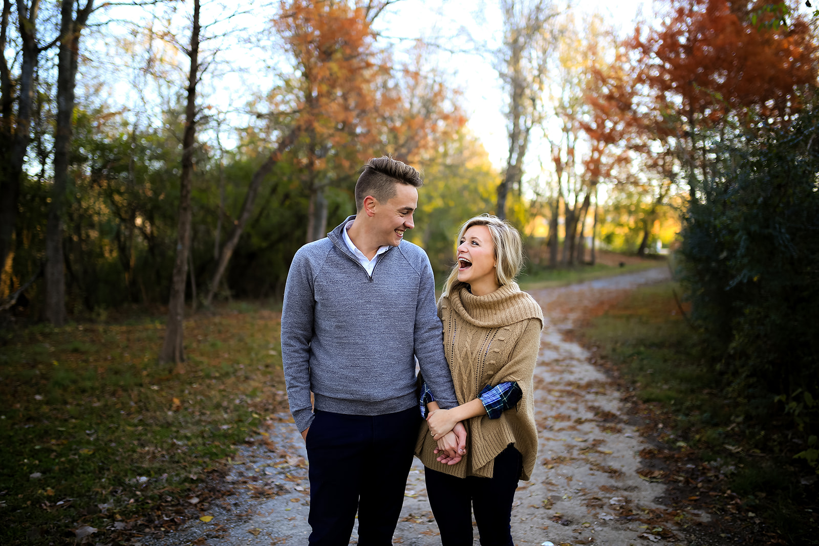 A man and woman walk hand-in-hand down a dirt path in Renaissance Park.