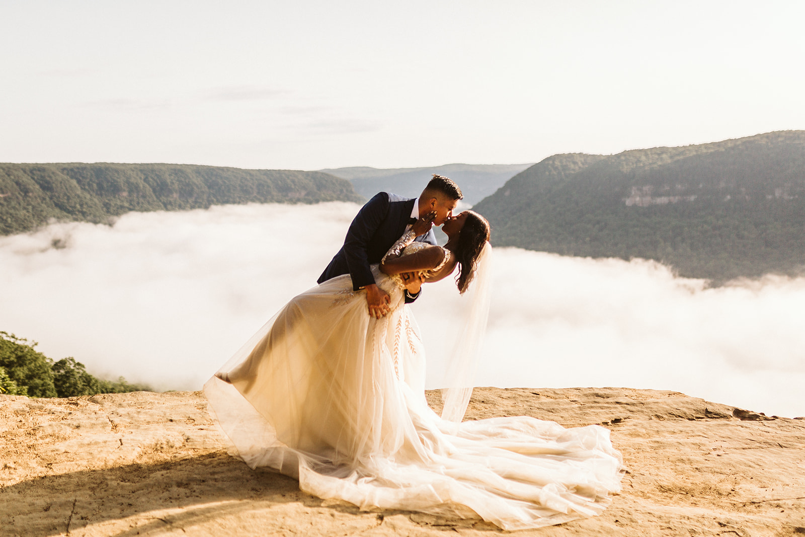 Groom dips bride on a mountain overlook during their engagement photo session near Chattanooga.