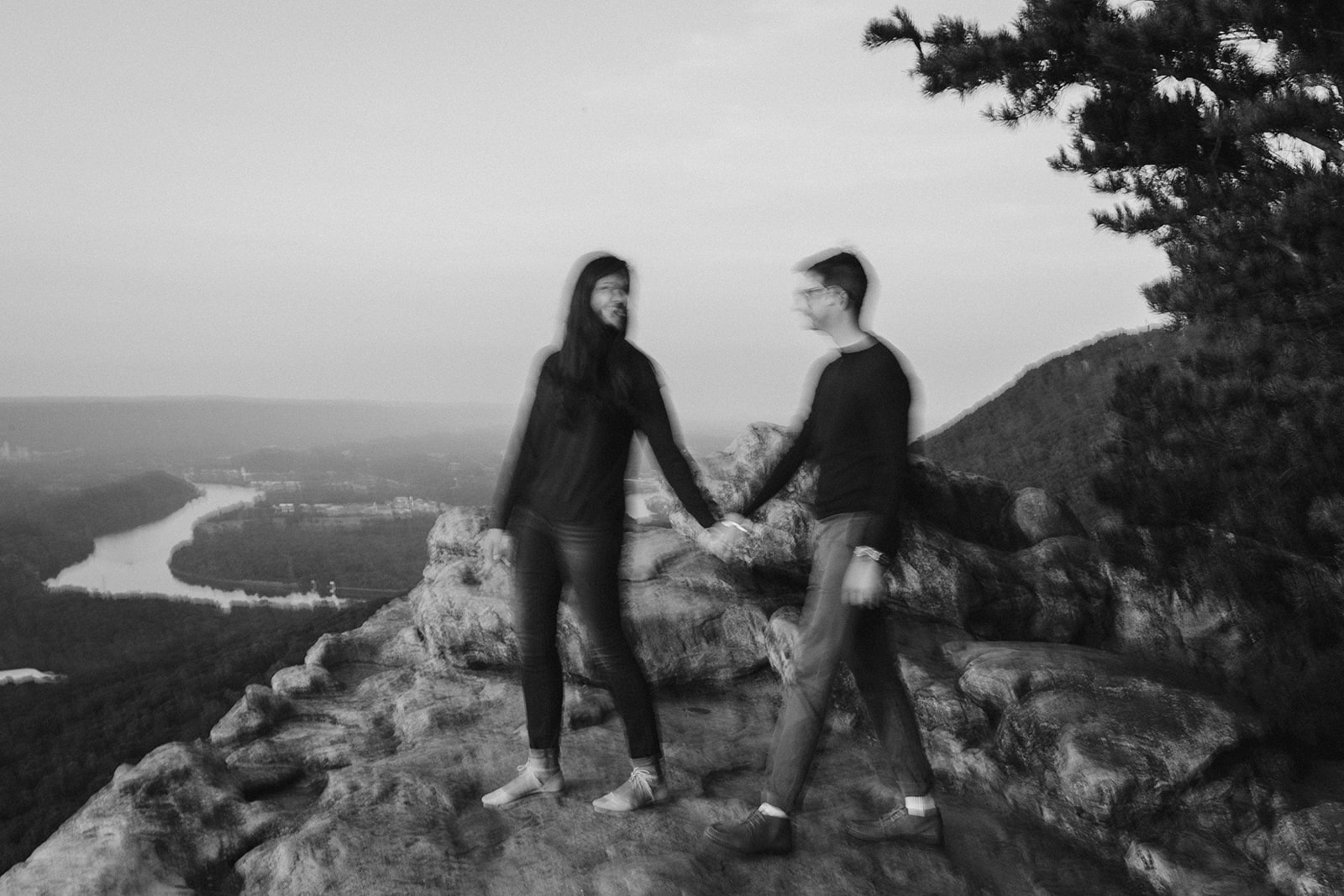 Couple walks hand-in-hand on a mountain overlook during their engagement photo session near Chattanooga.