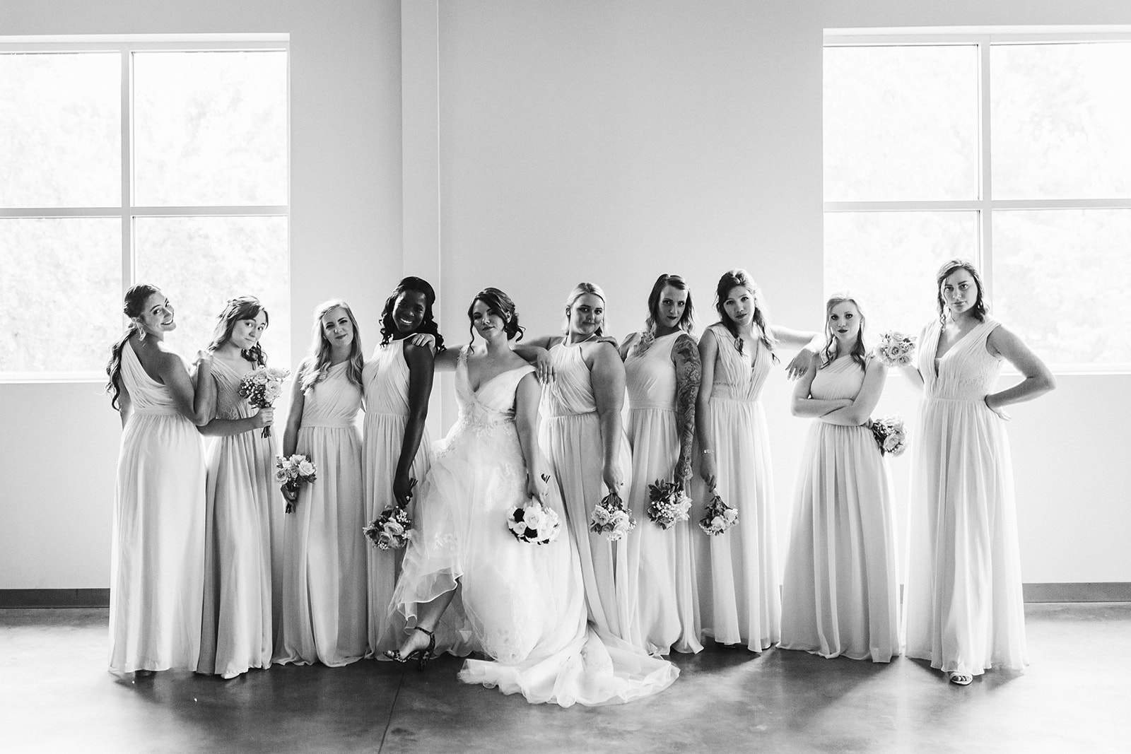 A black and white image of a bride posing with her bridesmaids.