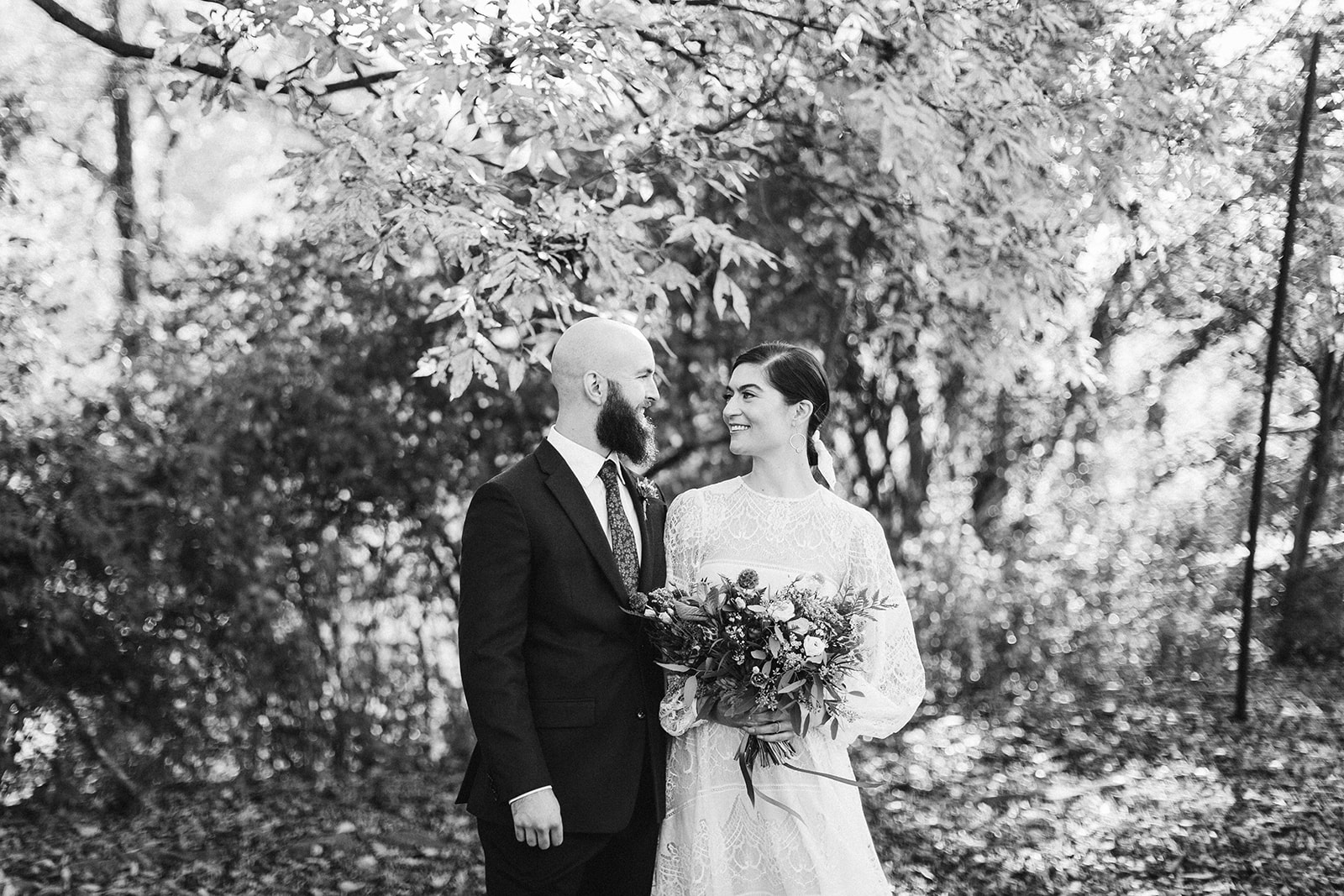 Black and white photo of the bride and groom smiling at eachother during their wedding at the Tennessee Riverplace