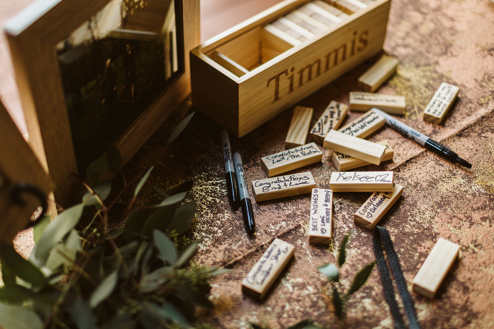 Wedding guests sign jenga pieces for the bride and grooms guest book