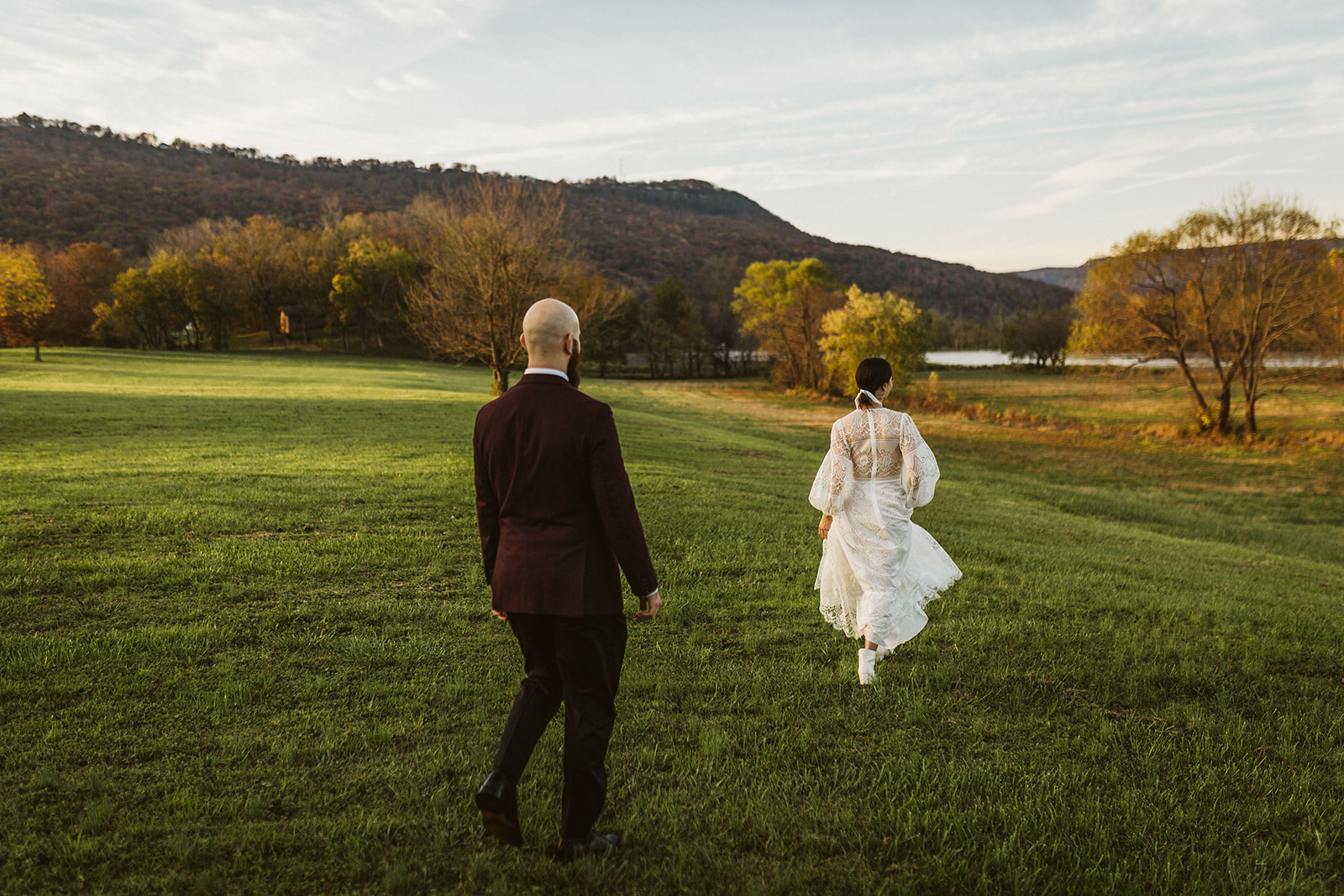 Groom watches bride as she runs through the Tennessee Riverplace fields in her wedding dress