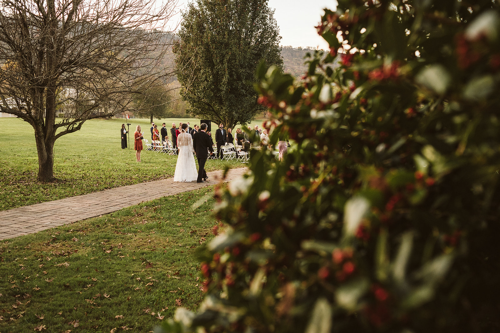 Wedding guests watch the bride and her father walk down the aisle at the Tennessee Riverplace