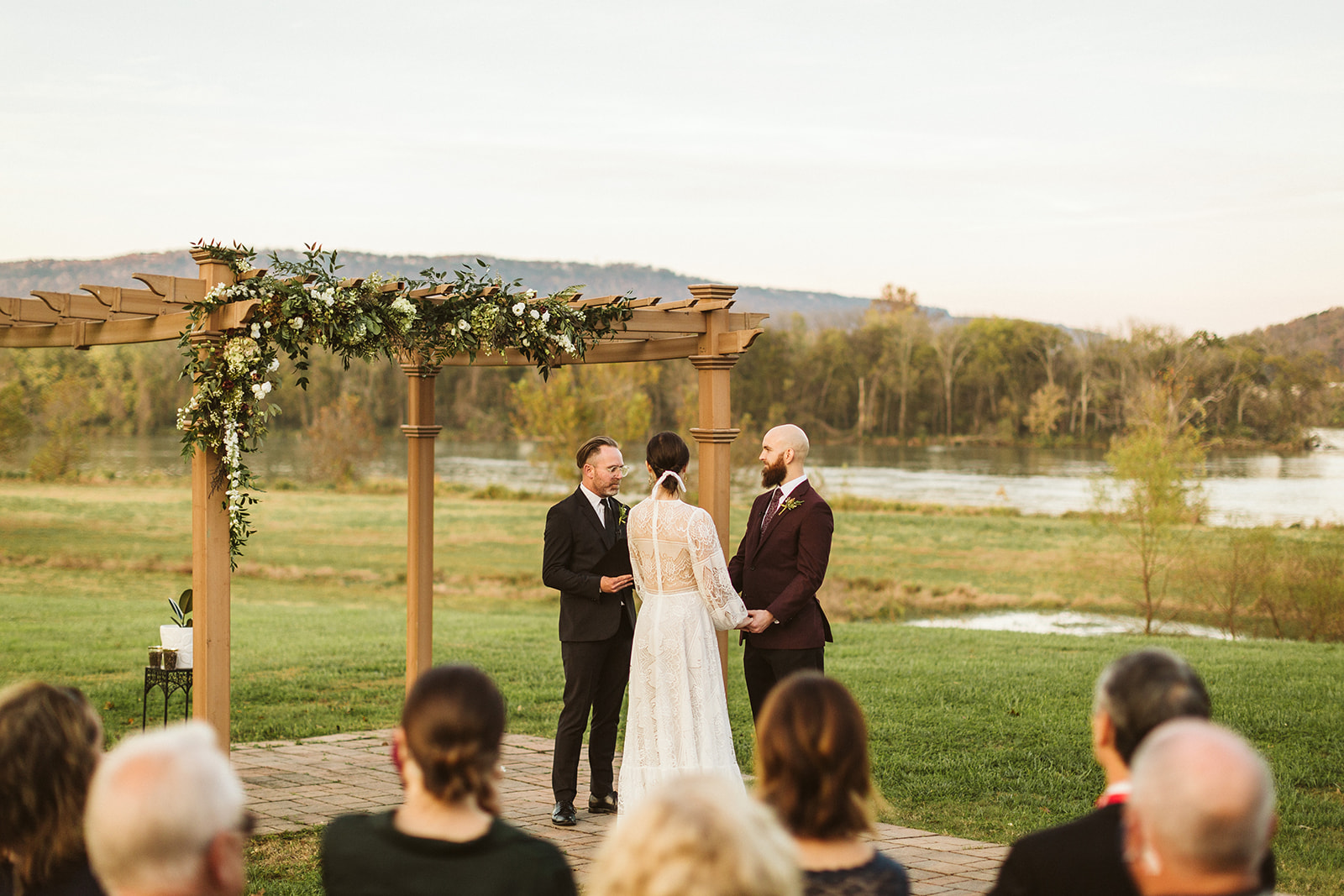 Bride and groom hold hands in the front of the alter at their wedding in the Tennessee Riverplace