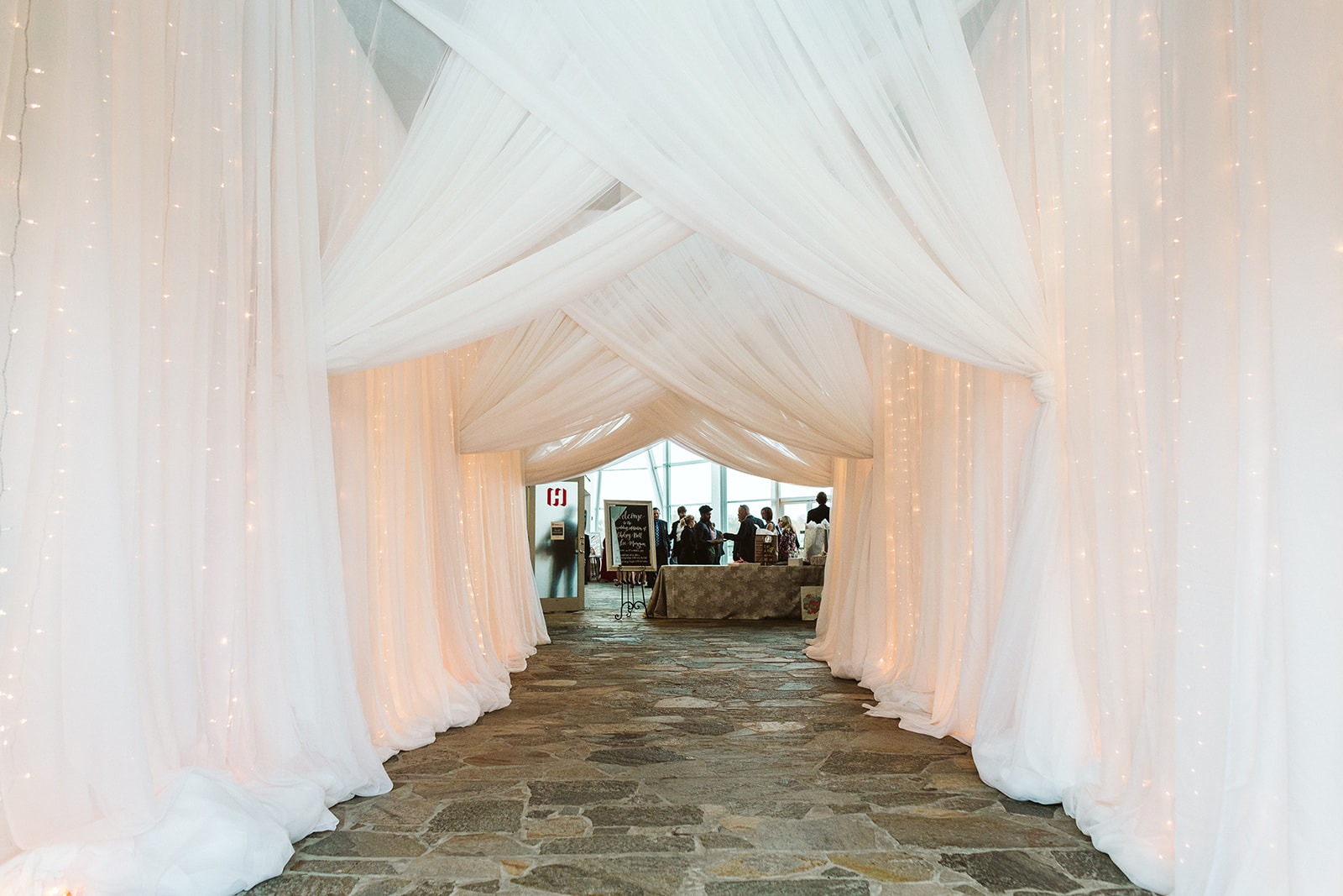 A hallway draped entirely in white tulle and fairy lights at The Hunter Museum.