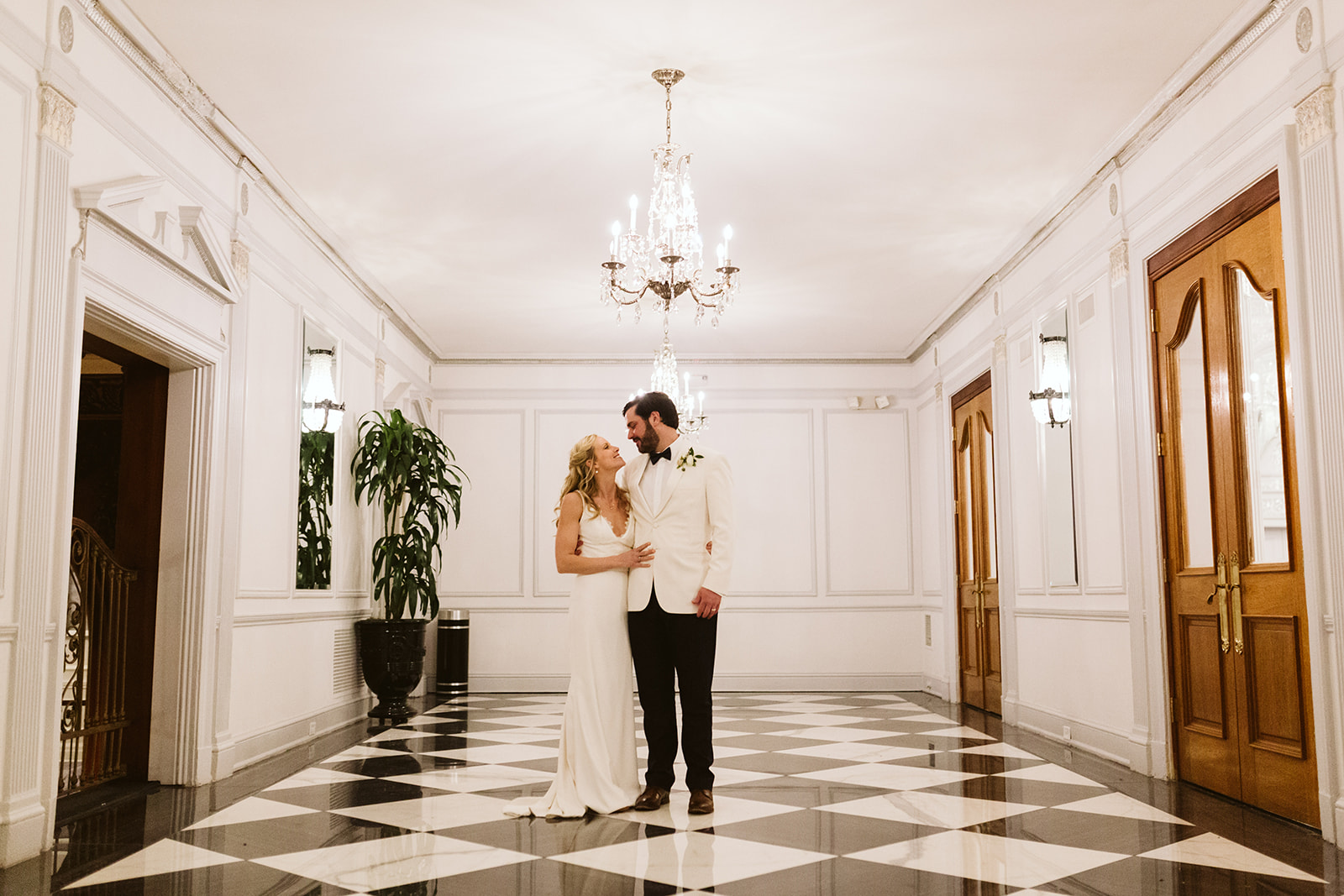 Bride and groom pose together beneath a chandelier at The Read House.
