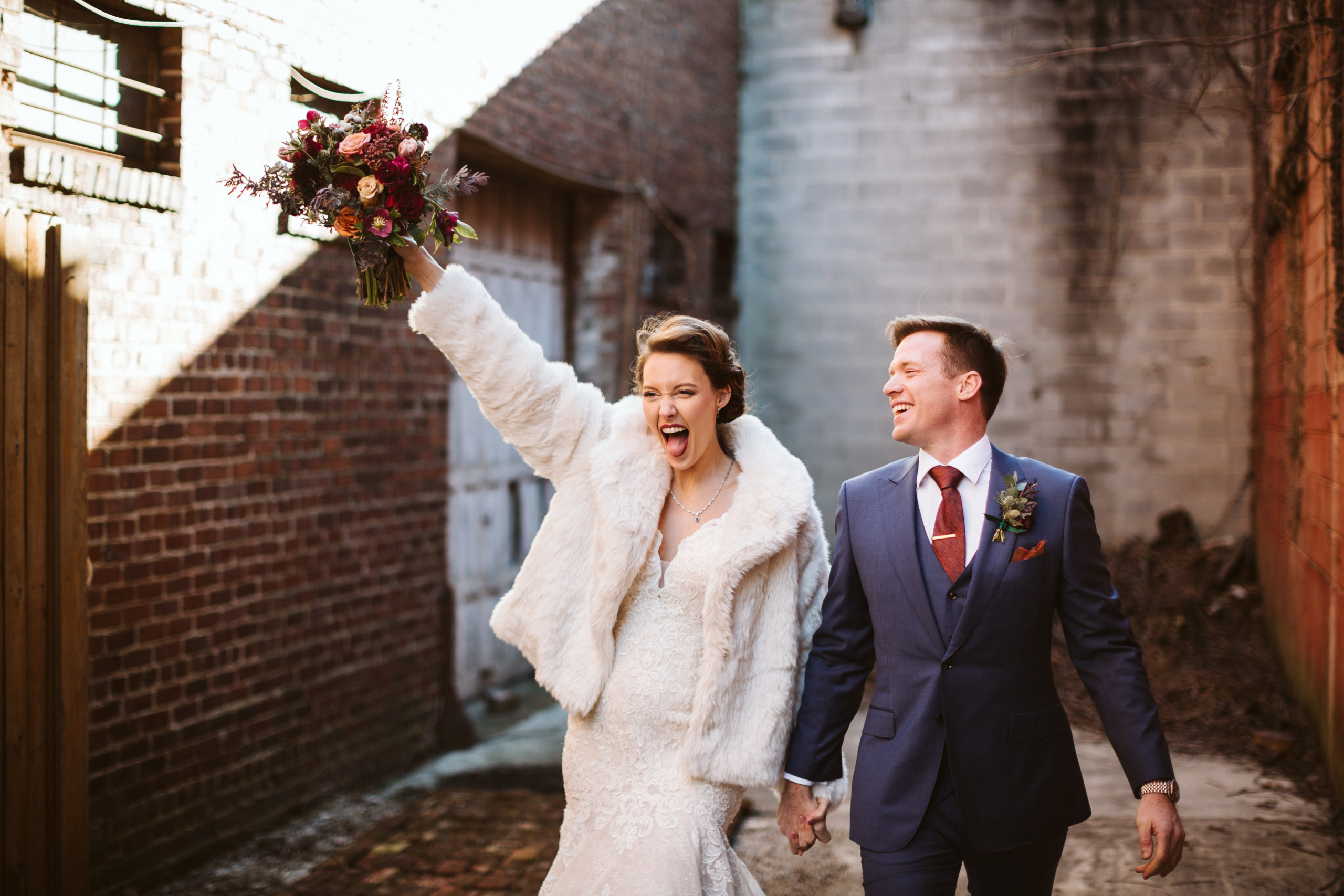 Bride and groom laugh together and celebrate their union in an alleyway outside The Turnbull Building.