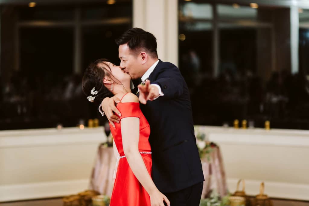 Bride and groom kissing happily during their first dance. Photo by OkCrowe Photography.