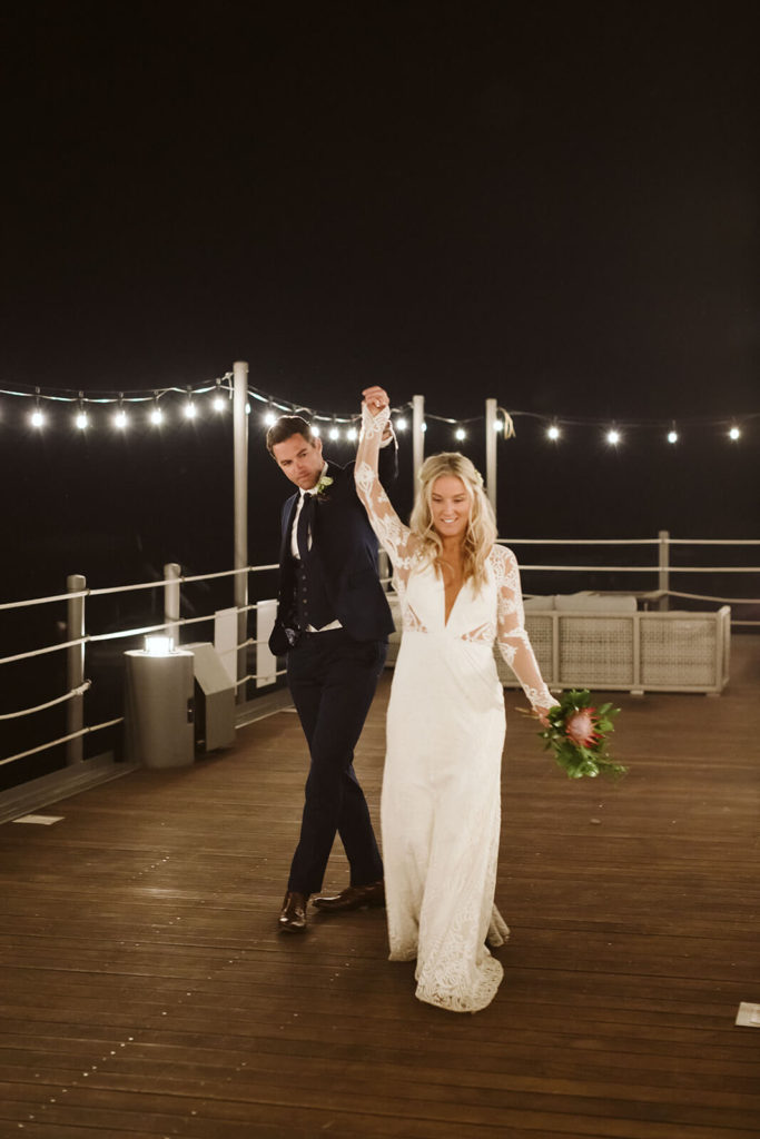 Nighttime bride and groom portraits on the pier of the Westshore Cafe and Inn. Photo by OkCrowe Photography.