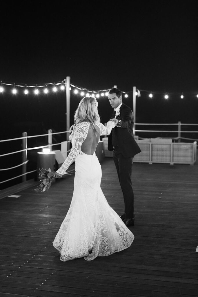 Nighttime bride and groom portraits on the pier of the Westshore Cafe and Inn. Photo by OkCrowe Photography.