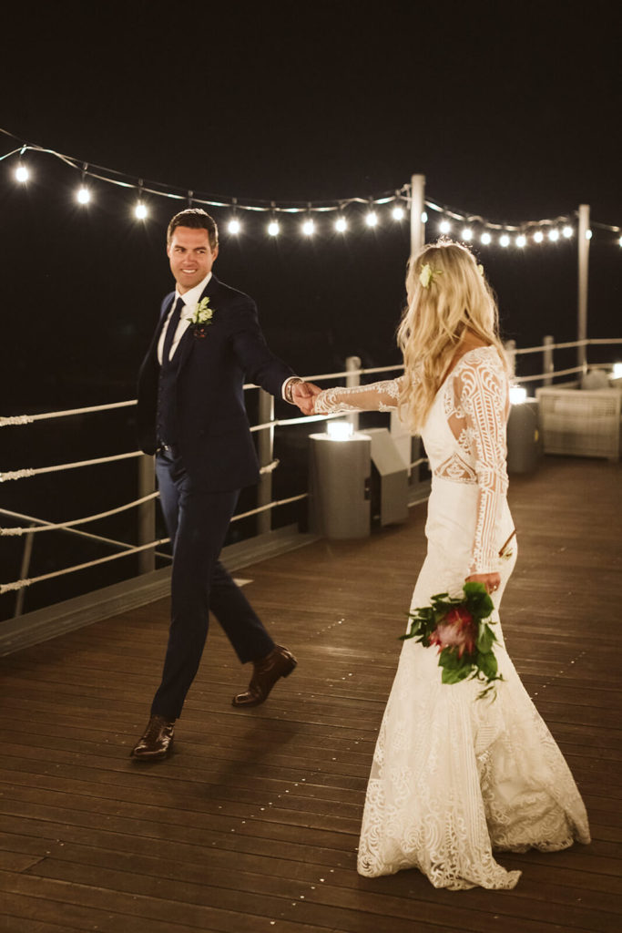 Nighttime bride and groom portraits on the pier of the Westshore Cafe and Inn. Photo by OkCrowe Photography.