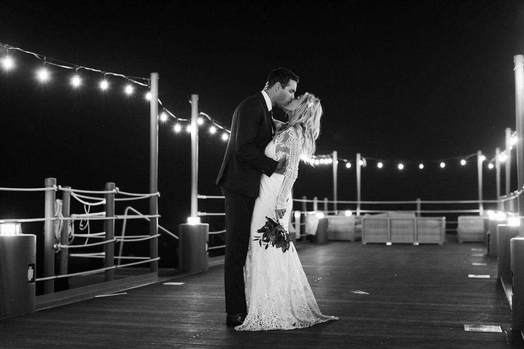 Nighttime bride and groom portraits on the pier of the Westshore Cafe and Inn. Photo by OkCrowe Photography.