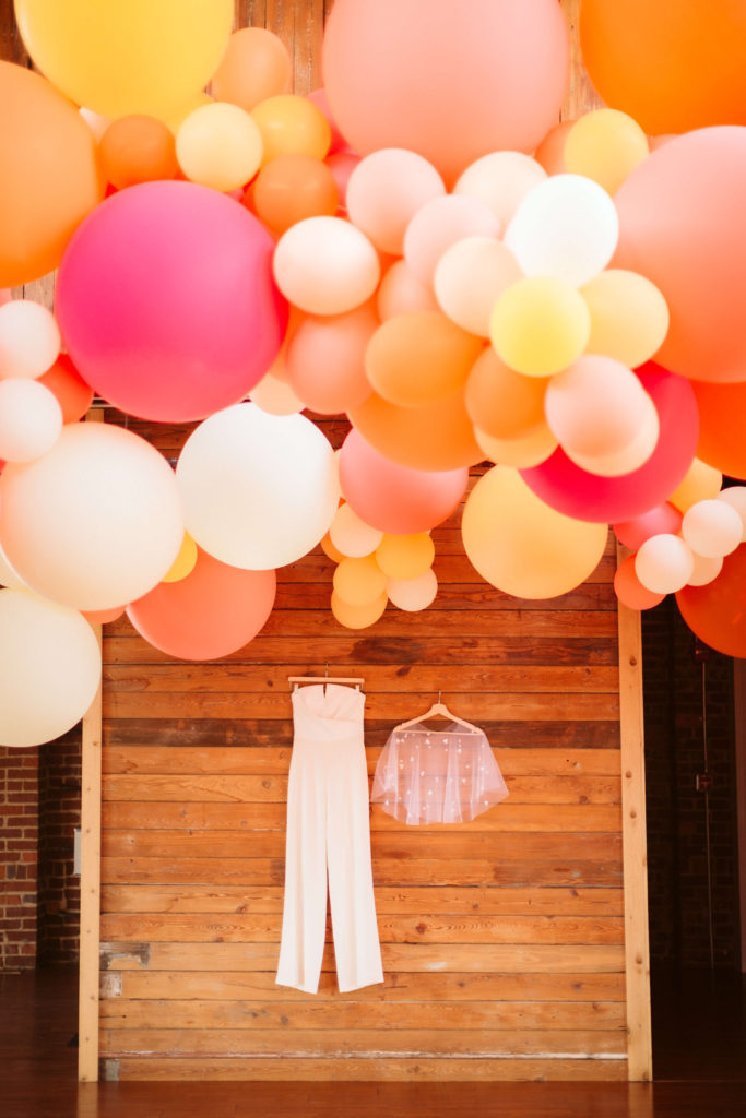 Bridal jumpsuit flatlay with sheer capelet. Photo by OkCrowe Photography.