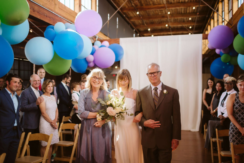 Modern industrial wedding ceremony at the Turnbull Building in Chattanooga with colorful balloon installation. Photo by OkCrowe Photography.