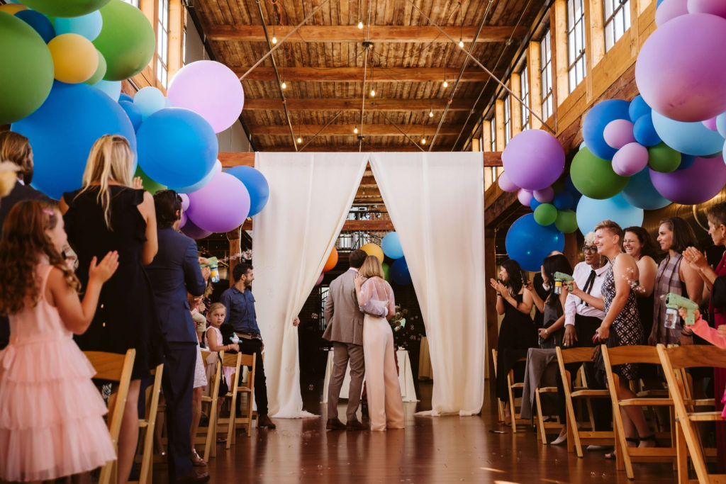 Modern industrial wedding ceremony at the Turnbull Building in Chattanooga with colorful balloon installation. Photo by OkCrowe Photography.