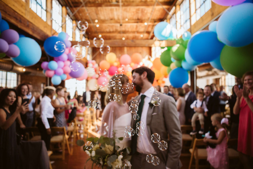 Modern industrial wedding ceremony at the Turnbull Building in Chattanooga with colorful balloon installation. Photo by OkCrowe Photography.