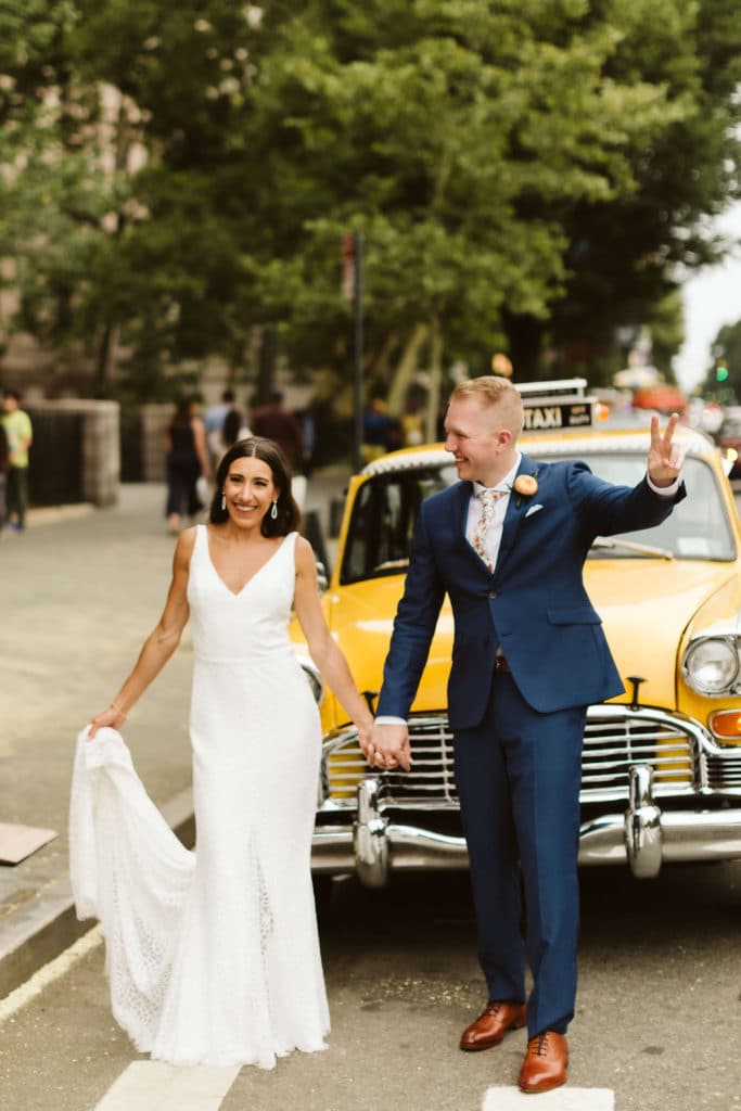 Bride and groom in front of NYC yellow taxi. Photo by OkCrowe Photography.