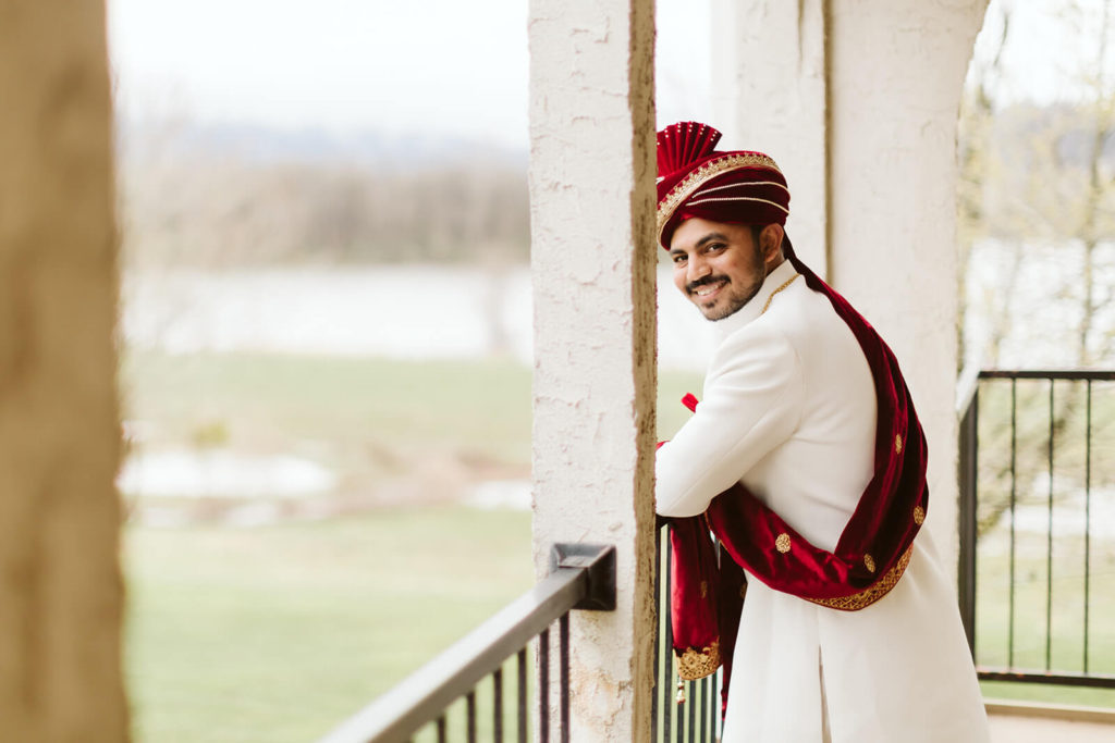 Indian groom standing on a balcony of Tenneessee Riverplace. Photo by OkCrowe Photography.