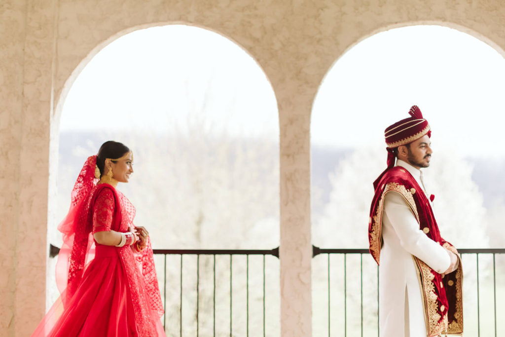 Indian bride approaching her groom for their first look. Photo by OkCrowe Photography.