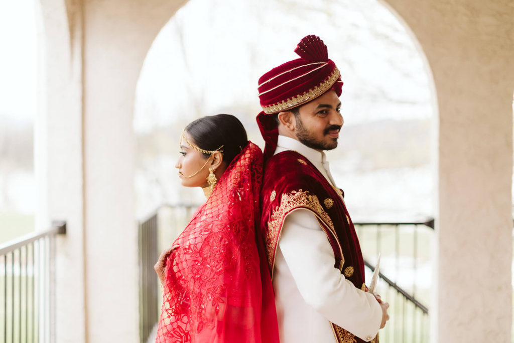 Bride and groom wearing traditional Indian wedding garments in an alcove of Tennessee Riverplace. Photo by OkCrowe Photography.