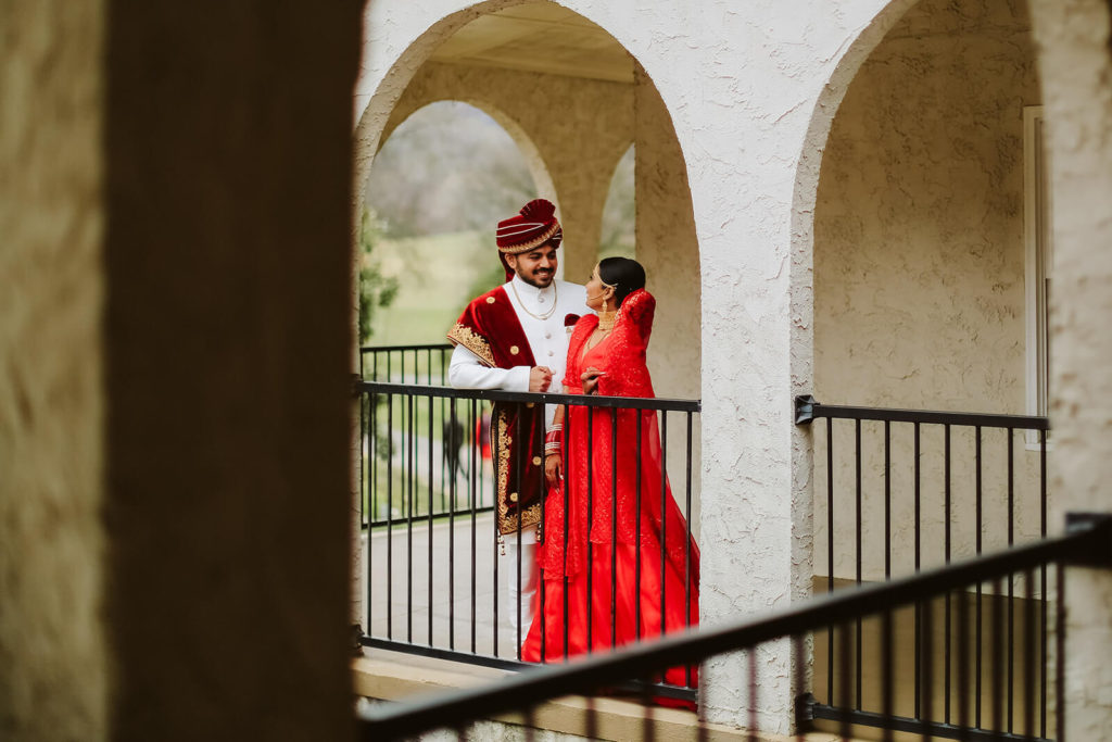 Indian bride and groom standing against the balcony in Tennesse Riverplace. Photo by OkCrowe Photography.