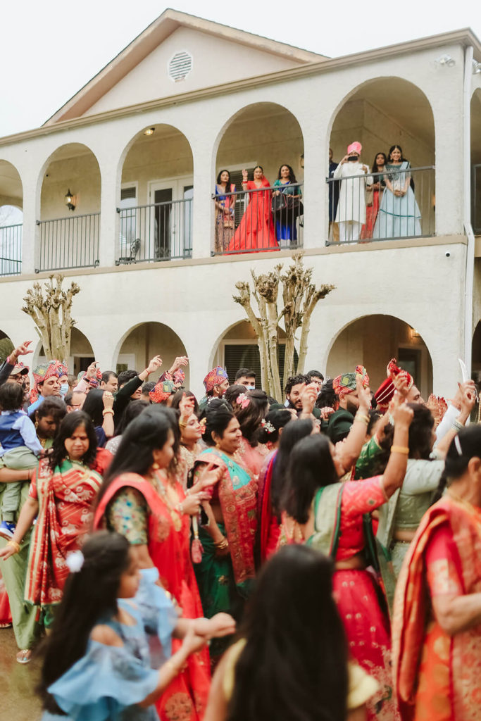 Bride and her family watching from the balcony during baraat. Photo by OkCrowe Photography.