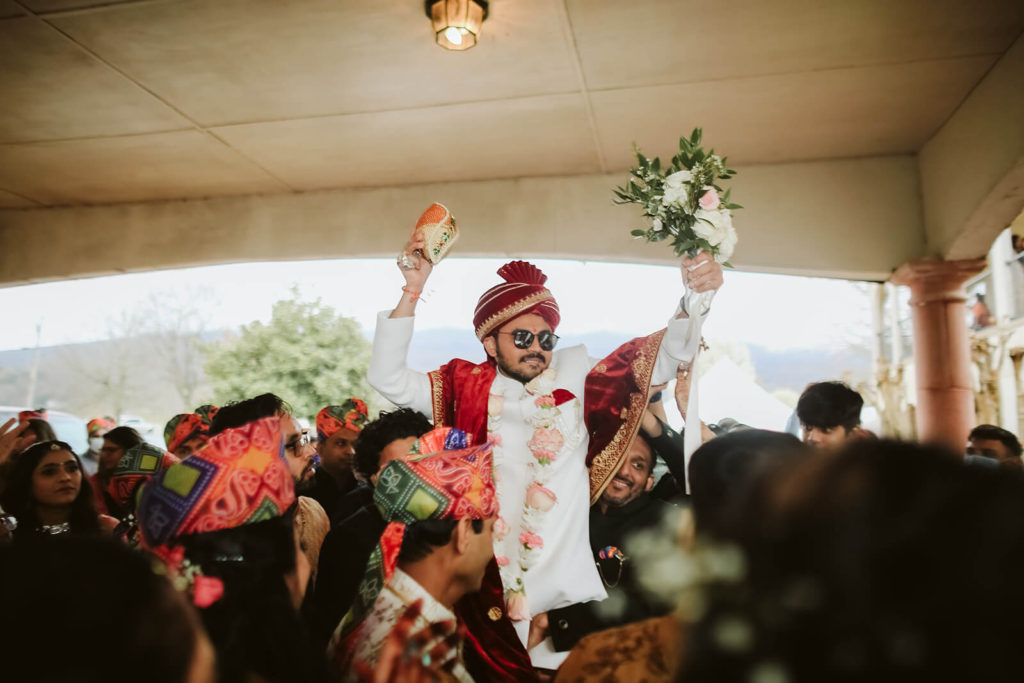 Indian groom arriving to the wedding venue during baraat. Photo by OkCrowe Photography.