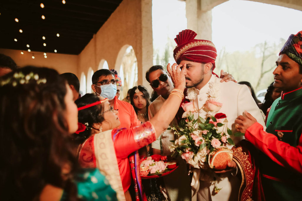 Indian groom being blessed with tilak. Photo by OkCrowe Photography.