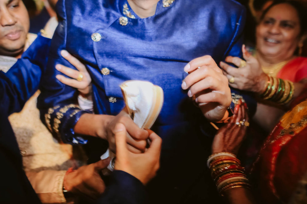 Stealing the groom's shoes during a traditional Indian wedding.