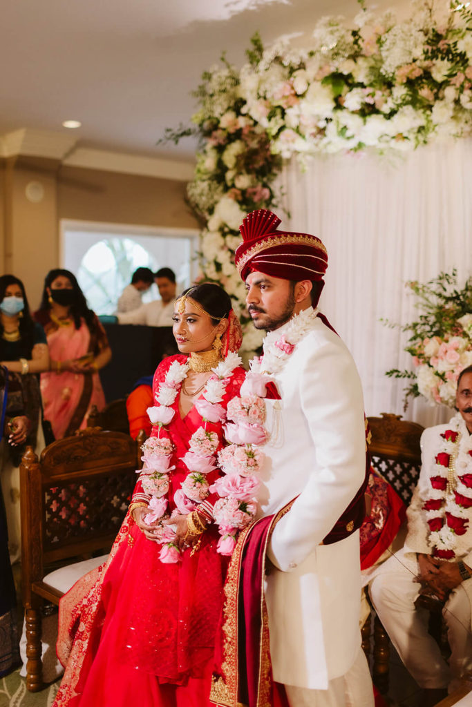 Indian bride and groom wearing floral garlands at their wedding ceremony. Photo by OkCrowe Photography.